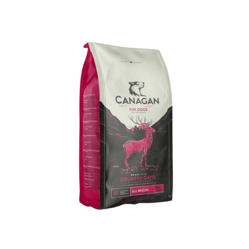 En påse med hundfoder från varumärket Canagan, märkt 'Country Game'. Påsen har en rosa och svart design med en bild av en hjort och berg i bakgrunden. Texten 'Grain Free' syns på förpackningen, och fodret är avsett för alla hundraser.