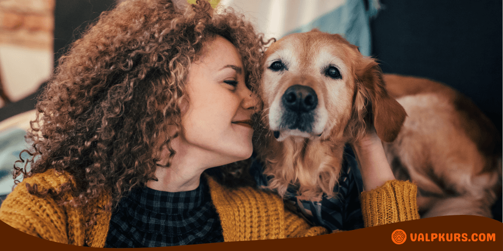 Kvinna myser med sin hund, symboliserar nära band och behovet av hygienprodukter för tikar.